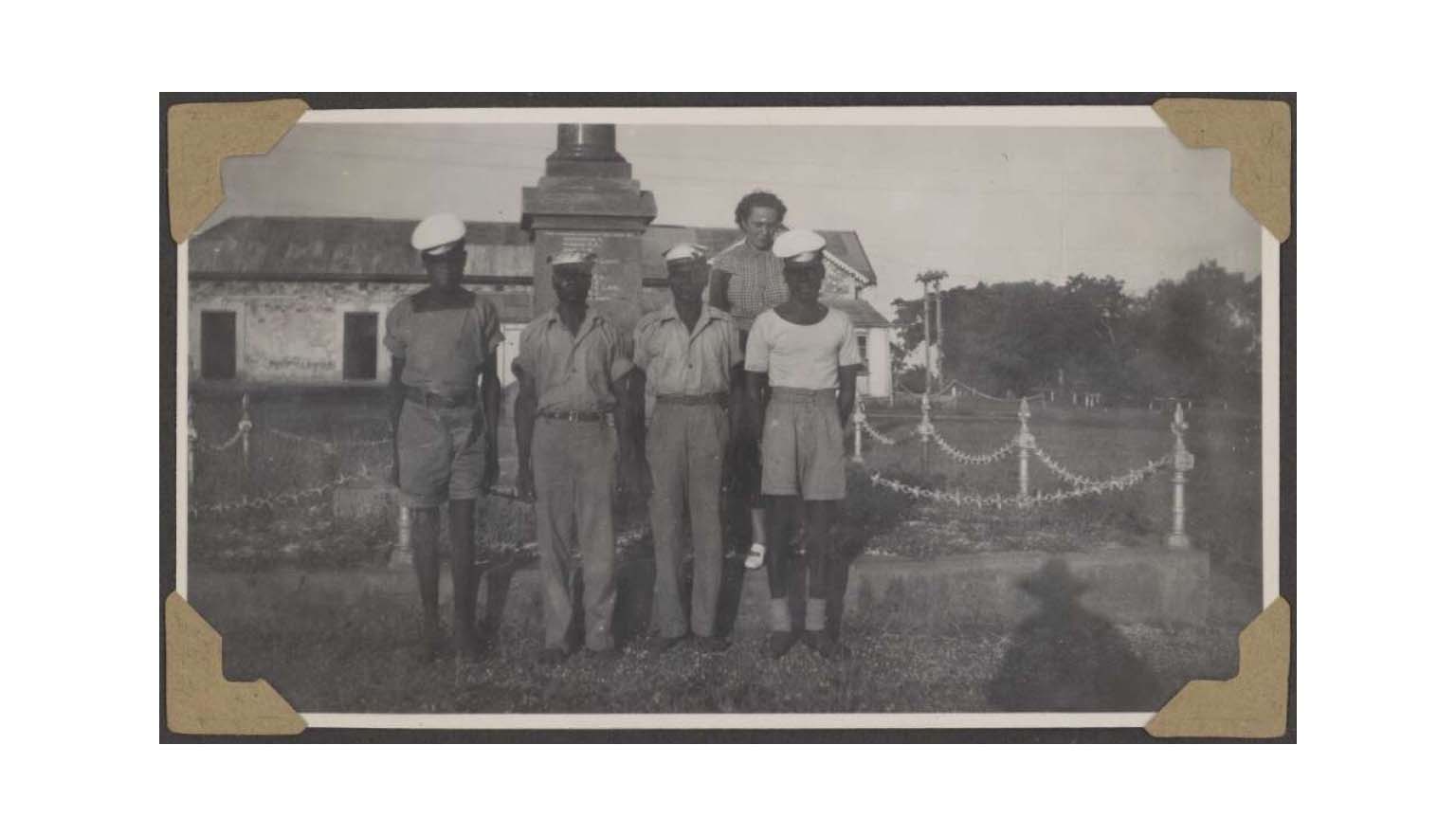 A group of Aboriginal men in military uniform stand outside a property