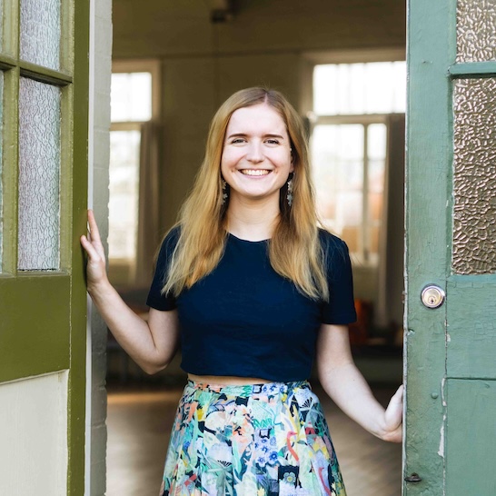 Illustrator Ingrid Bartkowia standing in a doorway smiling