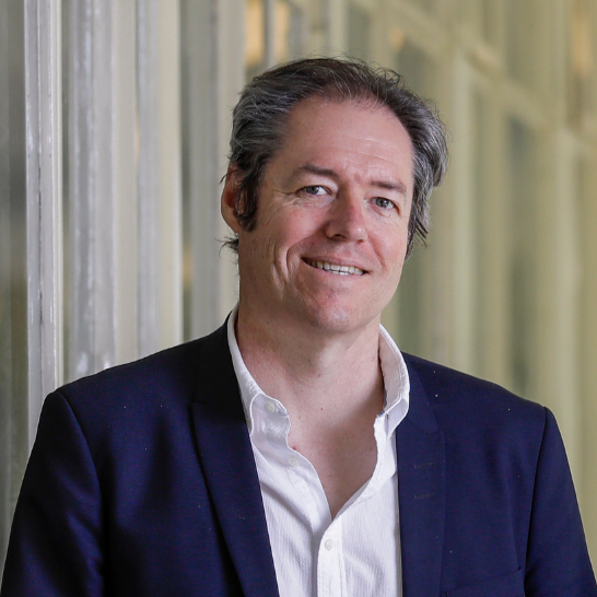 Photo of author Martin Thomas smiling and wearing a suit