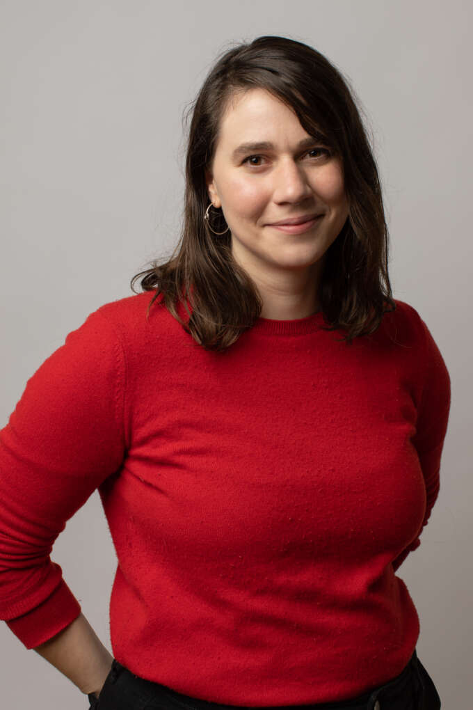 A women with long dark hair wearing a red sweater