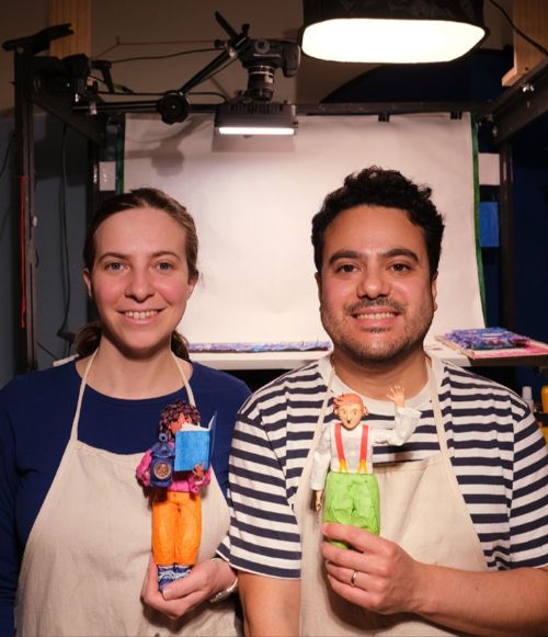 A headshot of a man and a woman holding painted figurines