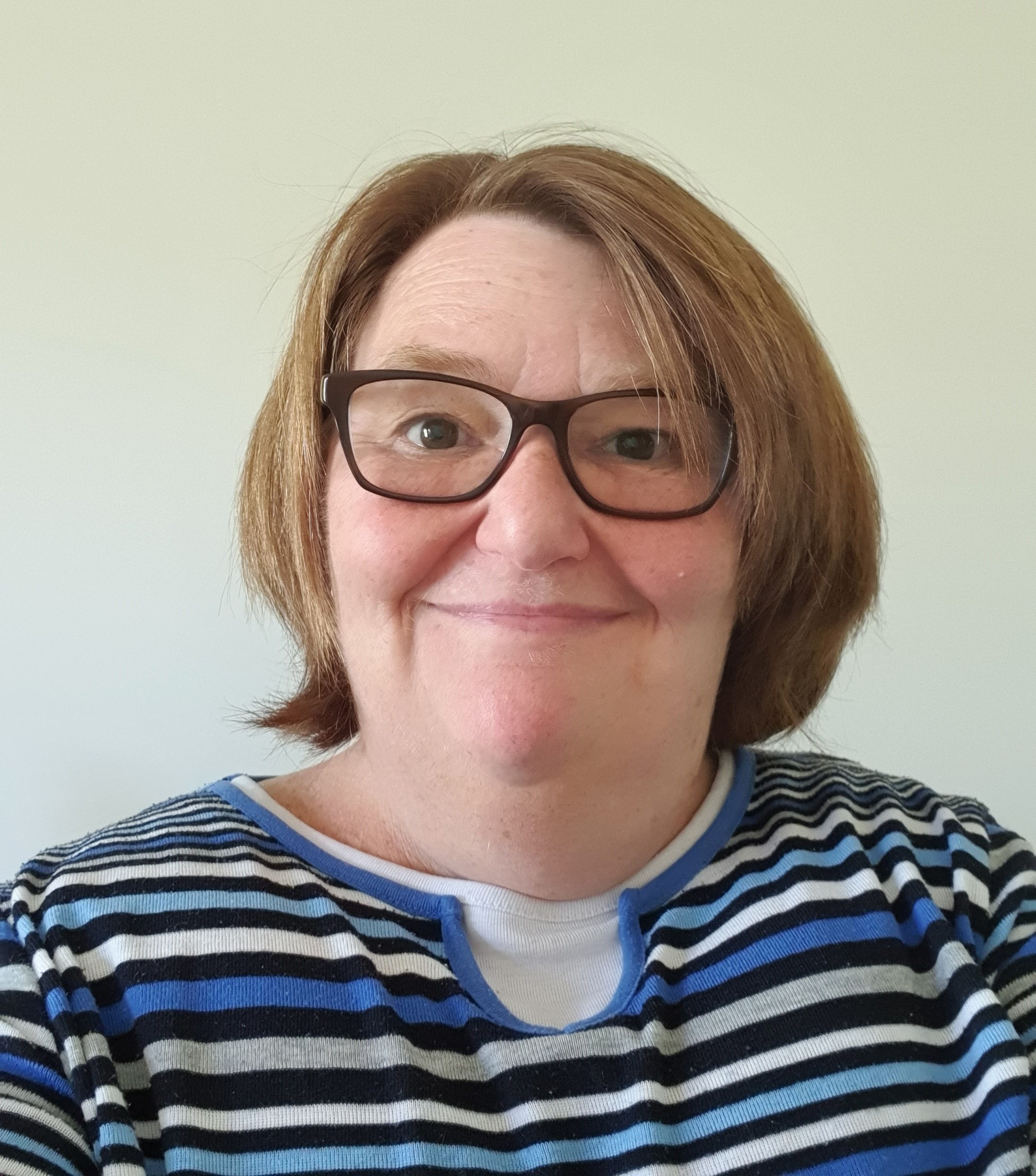 Portrait of a woman wearing glasses and a striped blue and white shirt