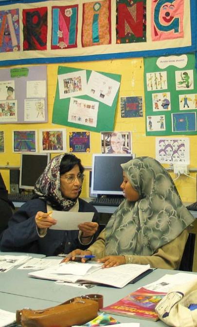 Women sit at a table talking to each other
