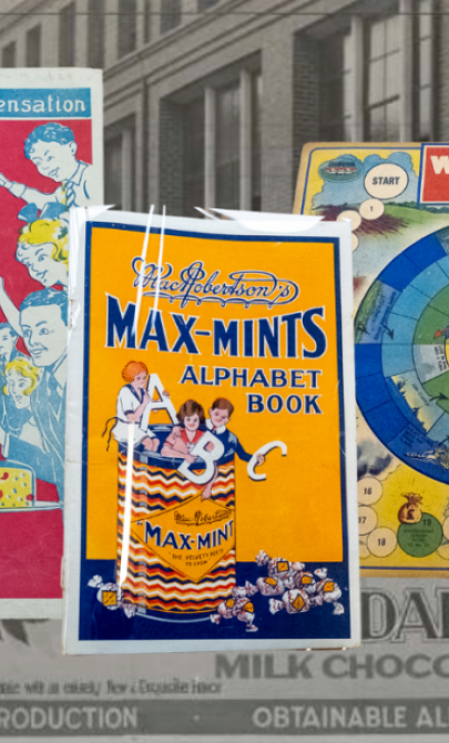 Three colourful advertisements, including a board game, photoshopped on a black and white background