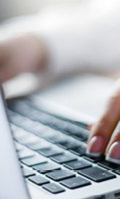 Photo of fingers resting on a laptop keyboard