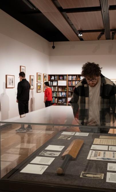 People in the gallery looking at Grit & Gold exhibition items