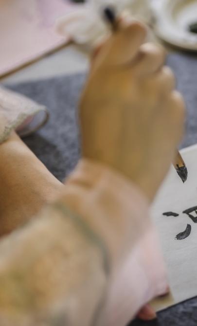 Close view of someone using a brush to write their name in Chinese calligraphy style