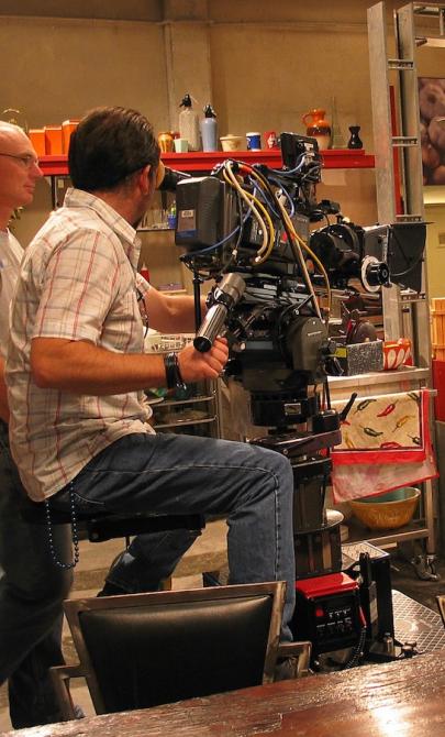 Two actors and a small film crew in a kitchen