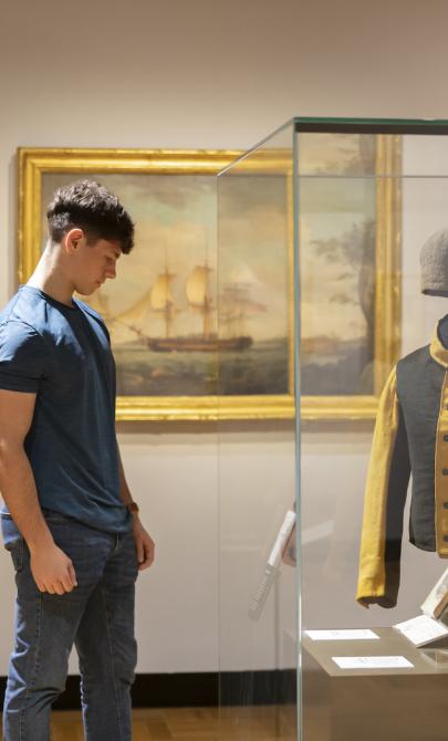 Young man looking at convict uniform on display in the gallery