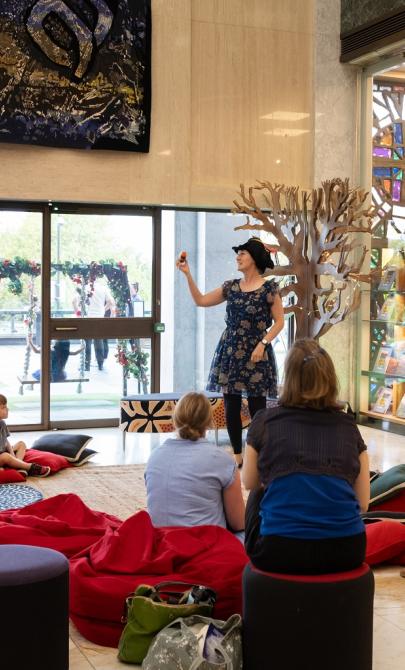 Author Kathy Weeden reading and acting out her book 'Phonobet' to children and their parents in the foyer during Enlighten