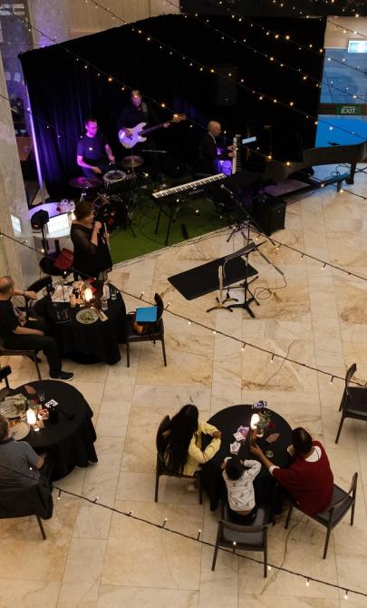 Library foyer with a band and singer performing in front of tables and fairy lights hanging from the ceiling