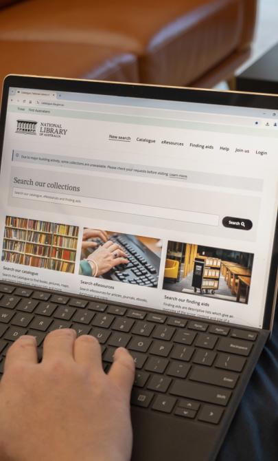 Man using a laptop to access the National Library catalogue