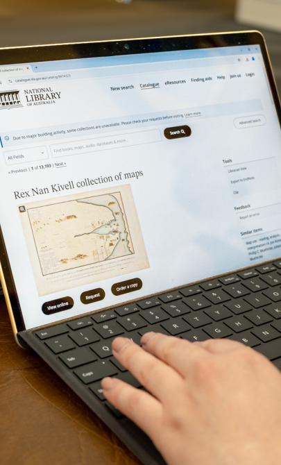Someone using a laptop looking at the catalogue record for the Rex Nan Kivell collection of maps in the National Library catalogue