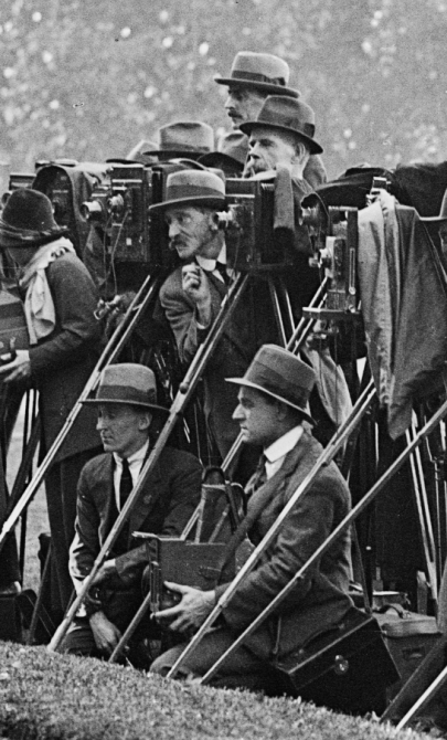 Black and white photo of photographers with large, old fashioned cameras in a line