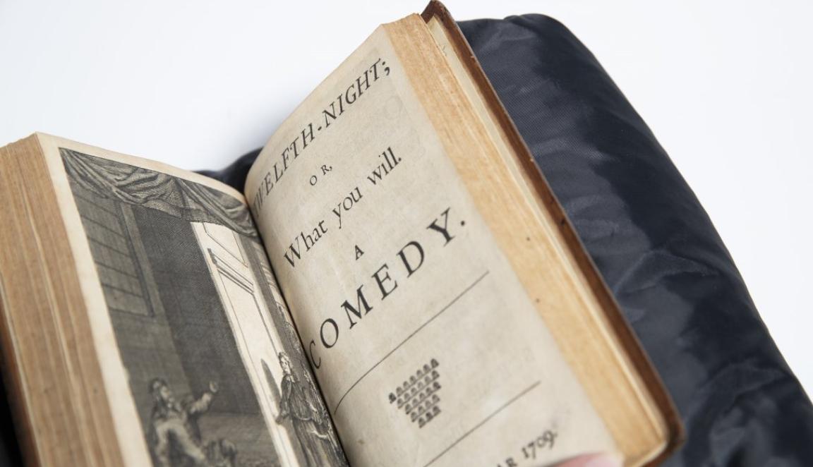 Old book open to black and white illustration and text reading 'Twelfth Night or What you will: a comedy'