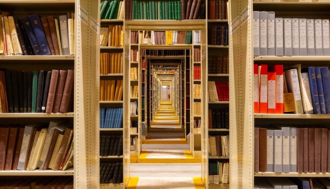 Rows of shelves filled with colourful books and doorways lined down the middle