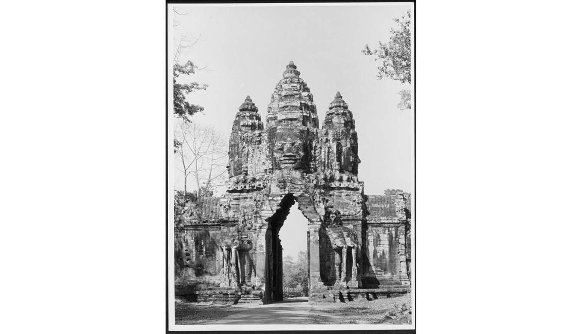 A black and white photograph of Khmer Temple gate surrounded by trees