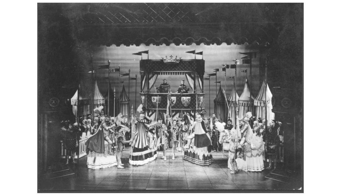 A theatre performance showing knights and soldiers before a royal audience.