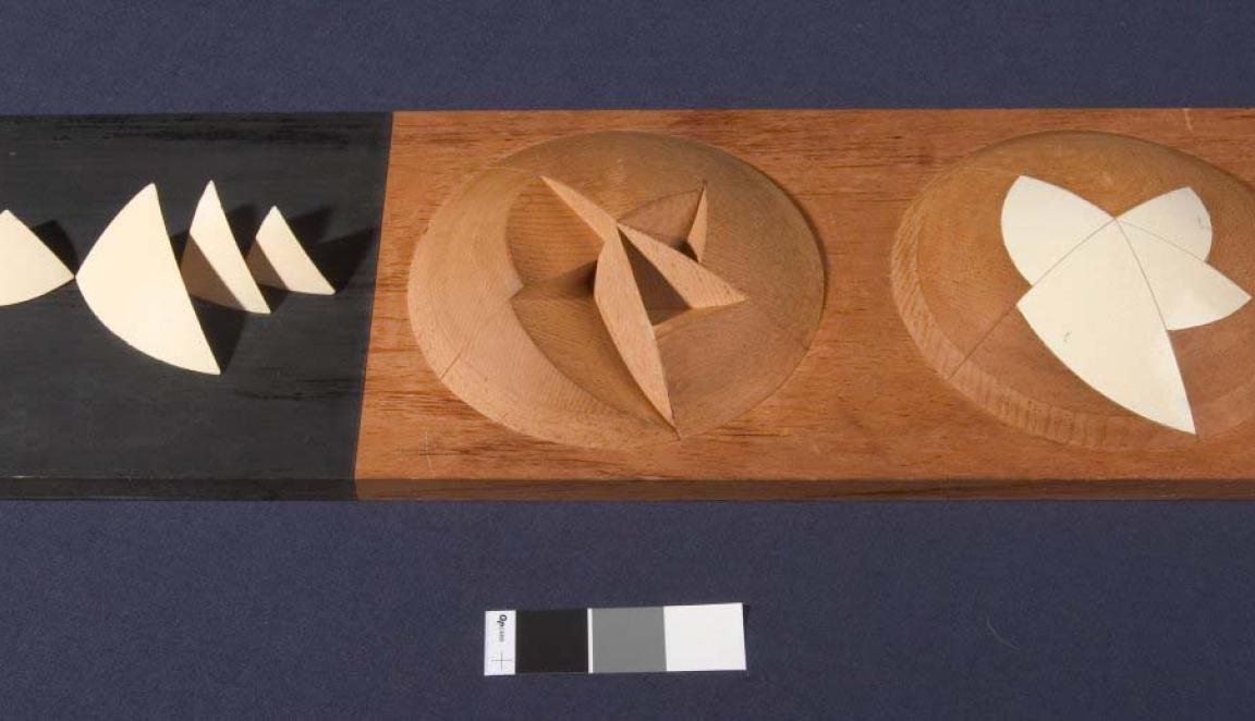 A stylised, abstract architects model of the Sydney Opera House. The model shows a hemisphere with triangular segments removed, another hemisphere shows the segments replaced to create a smooth surface.