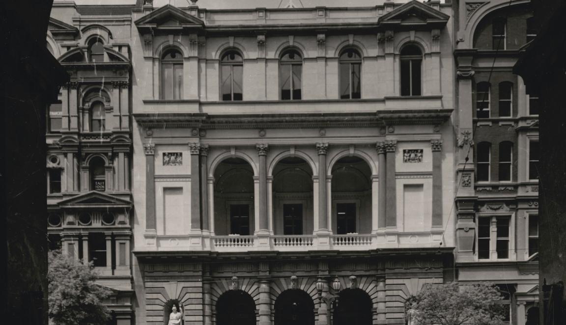Black and white photo of a more traditionally designed building seen through an archway