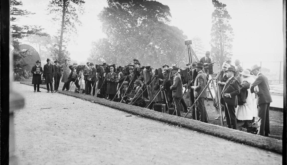 Black and white photo of photographers with large, old fashioned cameras in a line