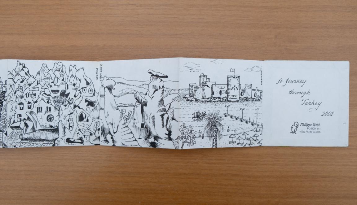 Fold-out travel diary open to four pages with black and white illustrations of landscapes and an island in Turkey