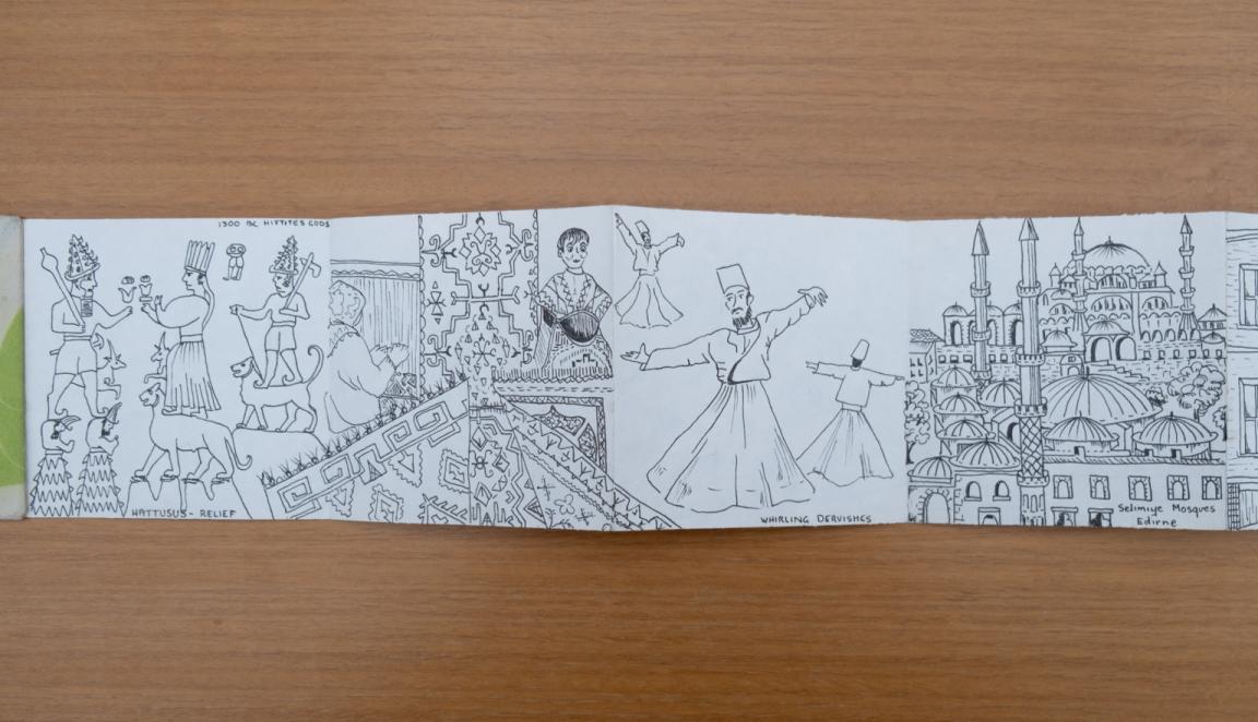 Fold-out travel diary open to four pages with black and white illustrations of people and city streets in Turkey