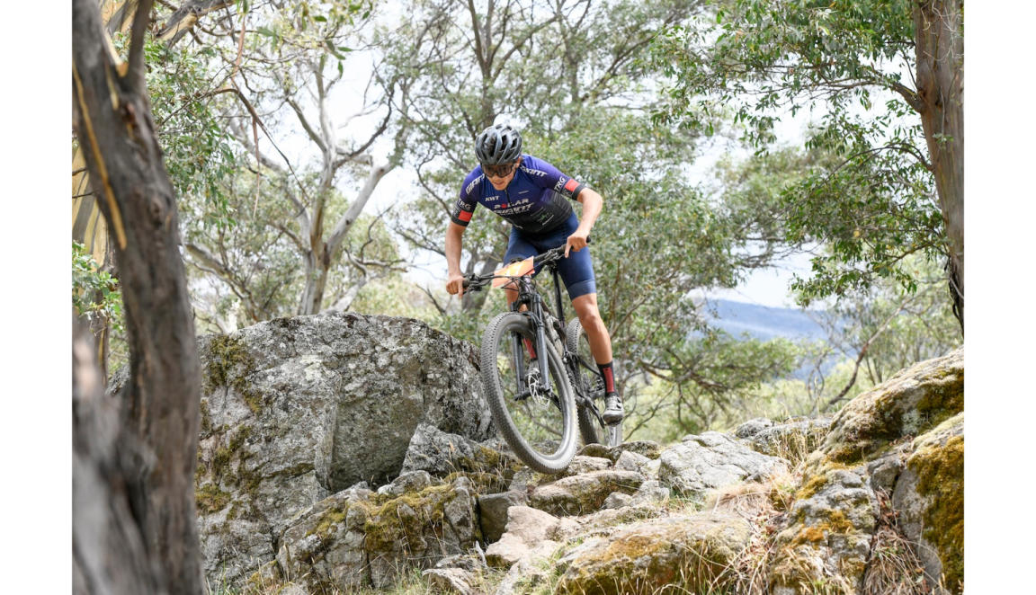 Mountain biker riding along rocks in a race