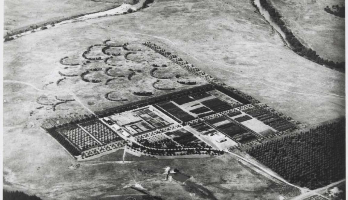 An aerial black-and-white photo of a field with a nursery