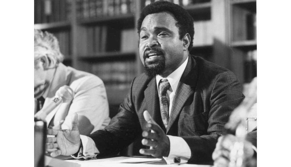 Michael Somare speaking while sitting at a table 