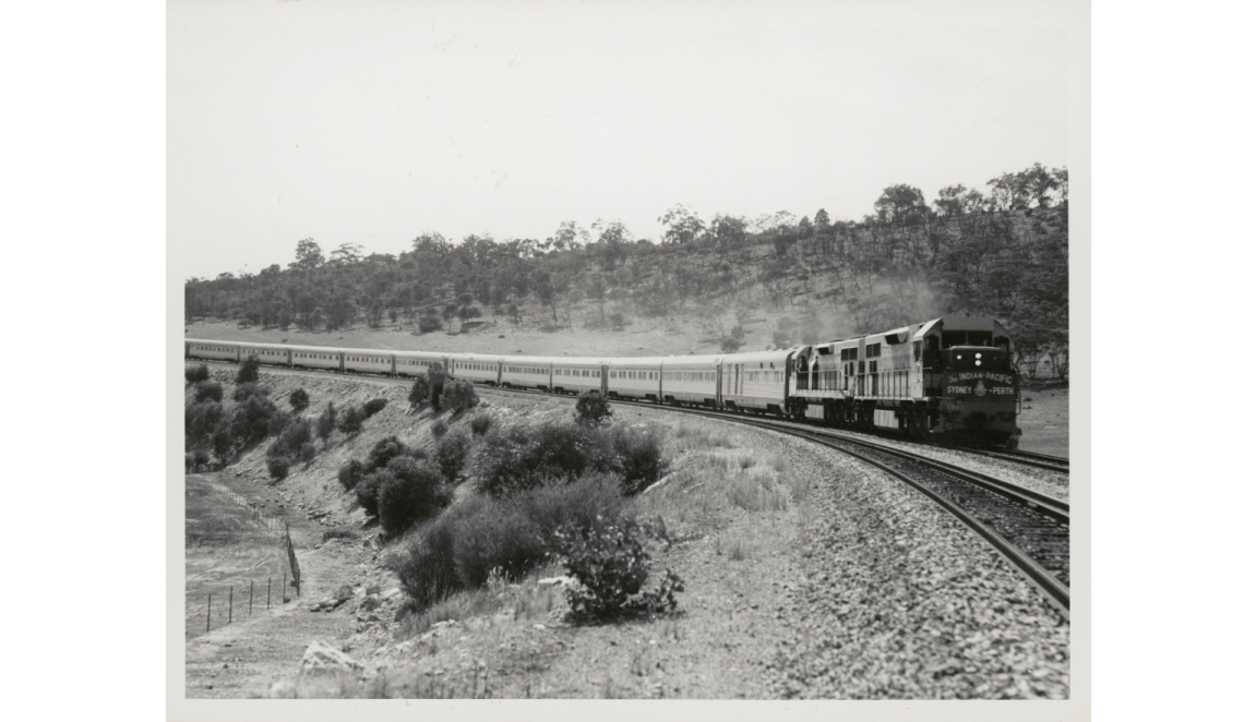 A black and white photograph showing a diesel train on a track