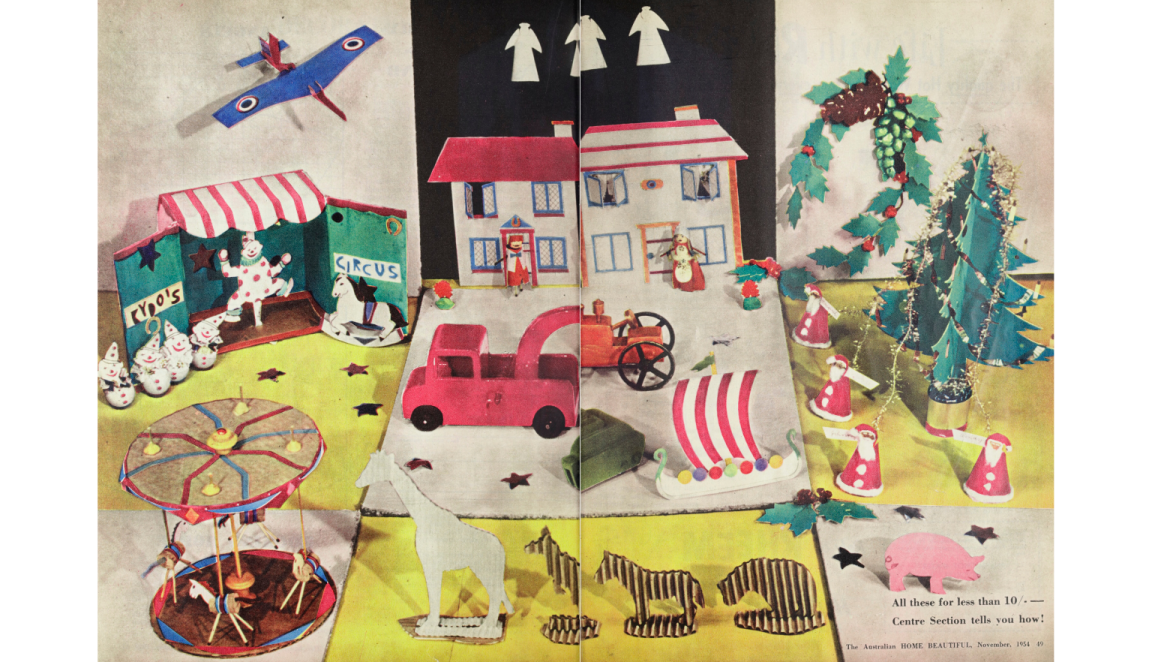 Double page spread of a magazine which is entirely a photo of colourful handmade Christmas crafts, including cardboard Christmas Trees and paper Santas and angels