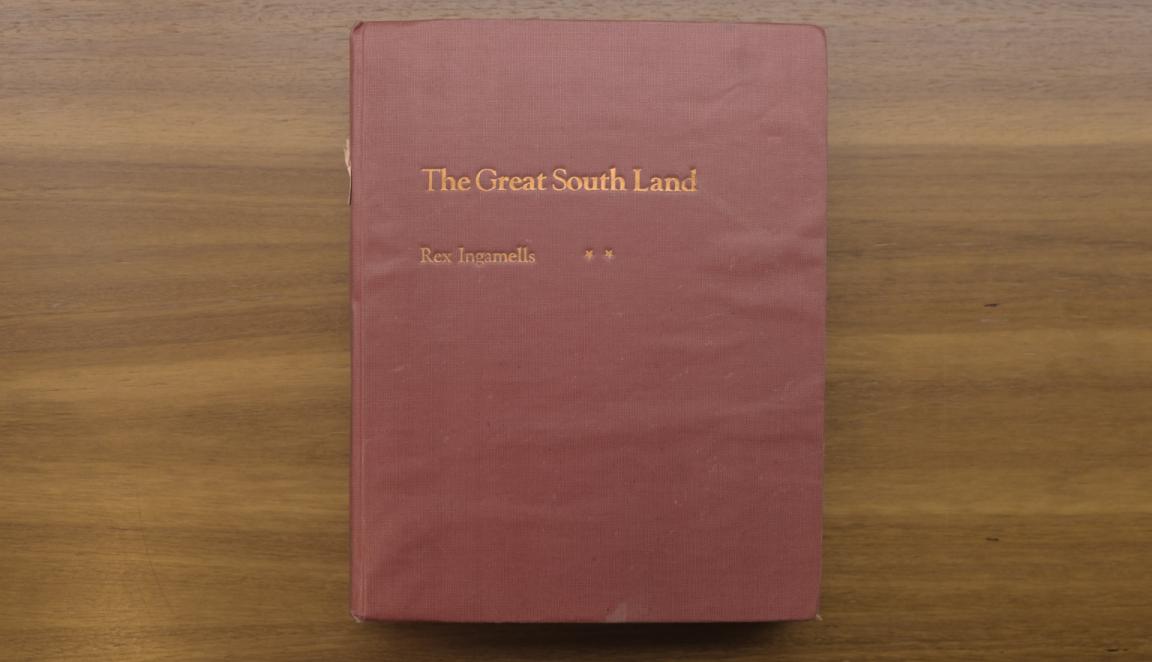 Cover of a red fabric bound book with gold text reading 'The Great South Land' and 'Rex Ingamells'