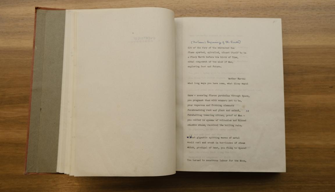Book open to a make with type-written words of a poem with handwritten annotations and minor edits