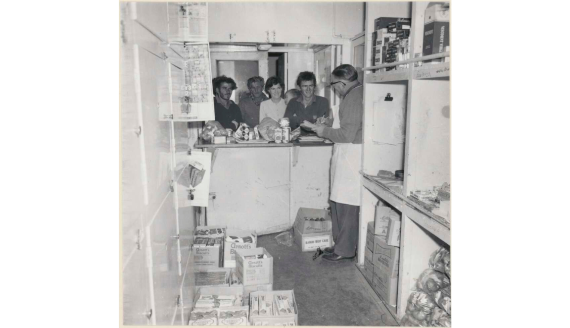 Three men and a woman holding a child at the provision store on the Tea and Sugar train on the Trans Australia Railway