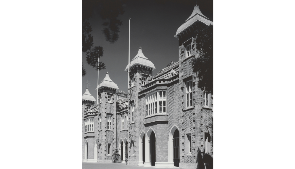 Black and white photo of Government House in perth, a brick building with several turrets and archways
