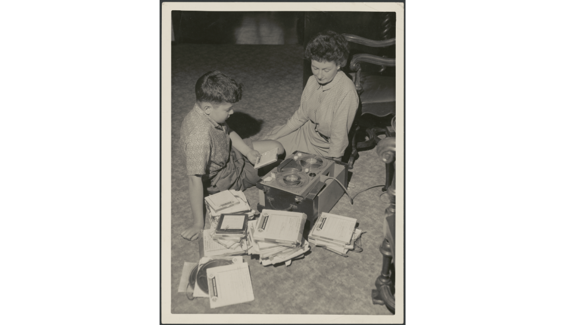 Black and white picture of Hazel de Berg sitting on the floor with her son