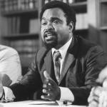 Michael Somare speaking while sitting at a table