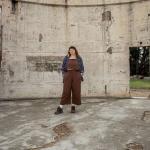 Karlie Noon standing in the burnt remains of a telescope at Mount Stromolo Observatory