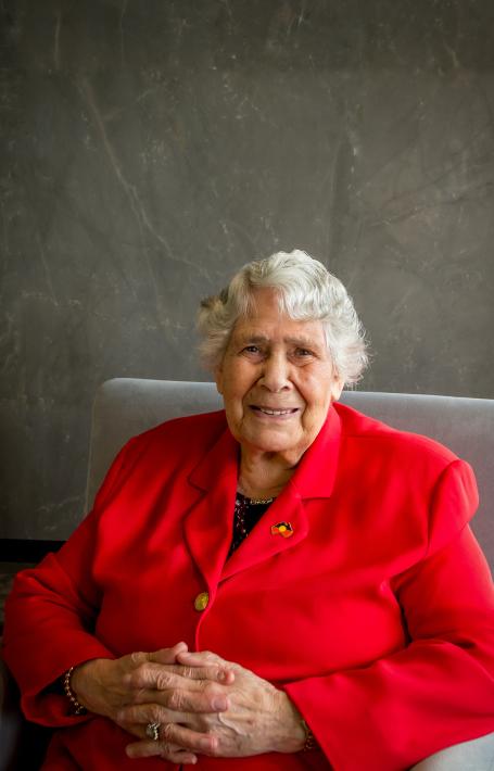 Dr Lowitja O'Donoghue sitting in an armchair and smiling