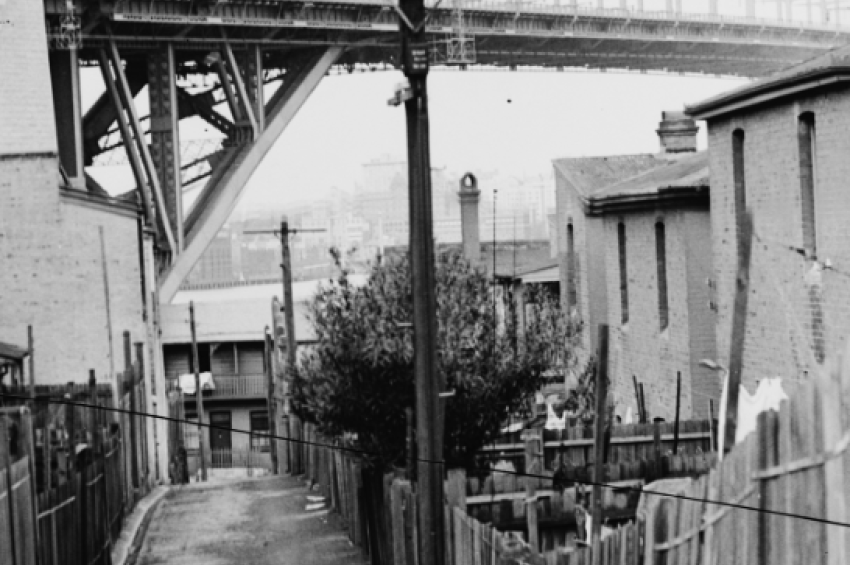 Black and white photo of Sydney Harbour Bridge viewed from a nearby street