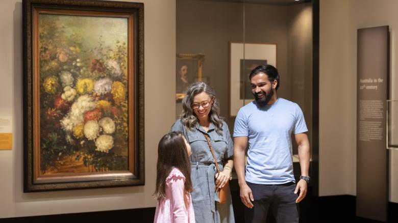Parents and child smiling and talking in the Library's Treasures Gallery