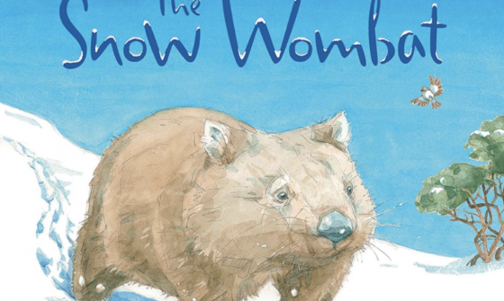 Book cover with blue text reading 'The Snow Wombat' and an illustration of a wombat walking through snow on a bright cloudless day