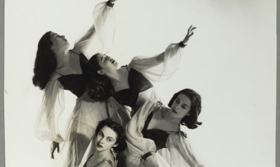 Four ballet dancers posing with their arms out and leaning in various directions