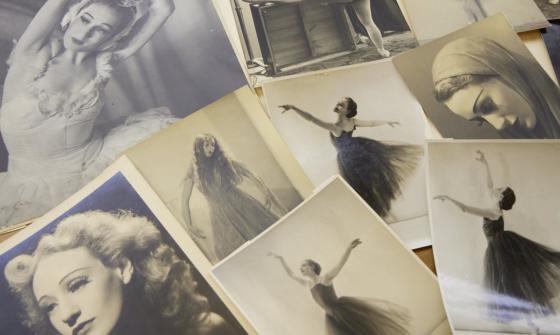 Photographs spread on a table, of a woman throughout her career in ballet, including photos of her dancing and portraits