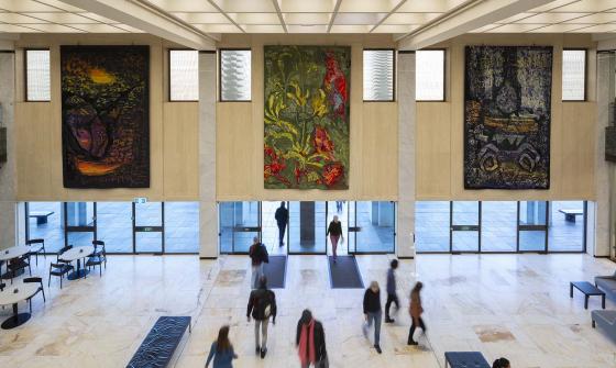 Three colourful tapestries hanging above the main entrance doors
