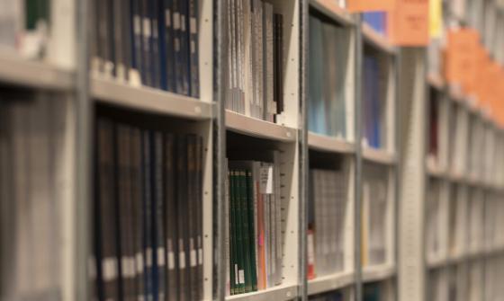 Long shelves of books and other print material with regular orange signs