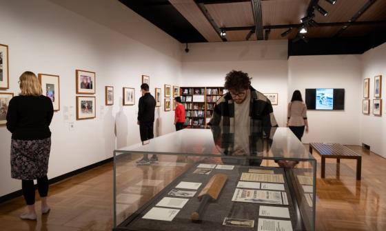 People in the gallery looking at Grit & Gold exhibition items