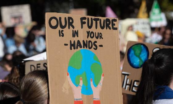 Protester holding a placard that reads, Our Future is in Your Hands