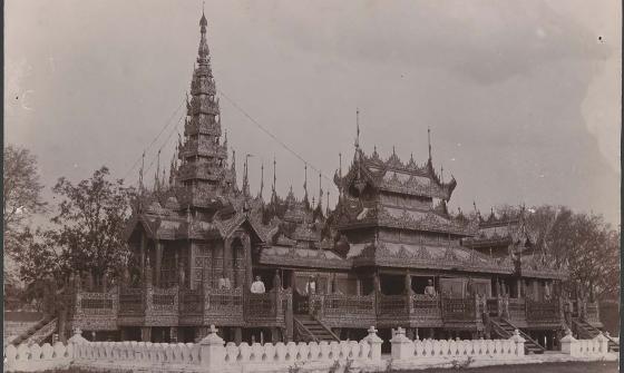 Sepia photograph of a monastery with people stanidng on the balconies